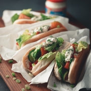 Hotdogs mit Lachs und Meerrettichsoße auf einem Holzbrett