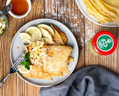 Teller mit Dinkelpfannkuchen mit Meerrettich, Minze, Apfel und Ahornsirup